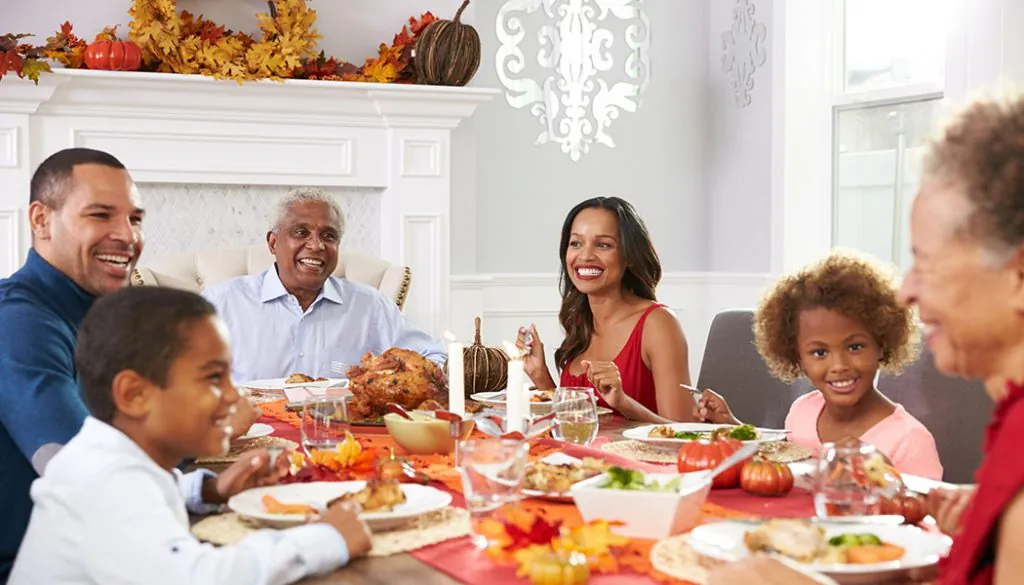 Enjoy A Healthy Thanksgiving With Family Three generations of family sit at table for Thanksgiving Dinner