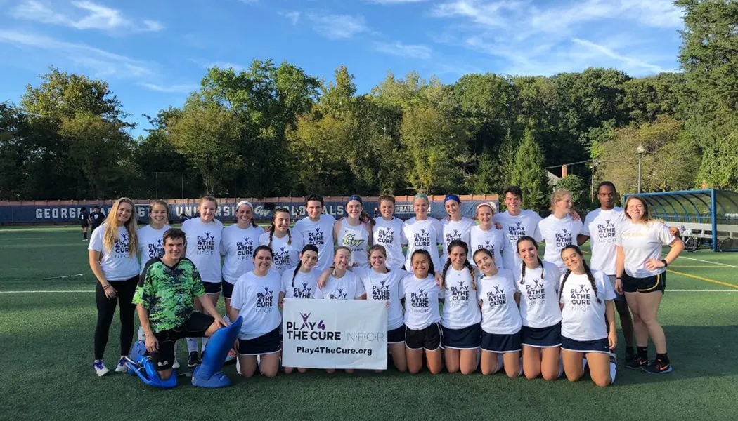 George Washington University Club Field Hockey Play4TheCure to support Childhood Cancer Research George Washington University Club Field Hockey Pose with Play4TheCure Banner on Field