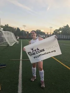 Community Service Chair, Jackie Clarke, Plays4theCure Field Hockey player with Play4theCure banner