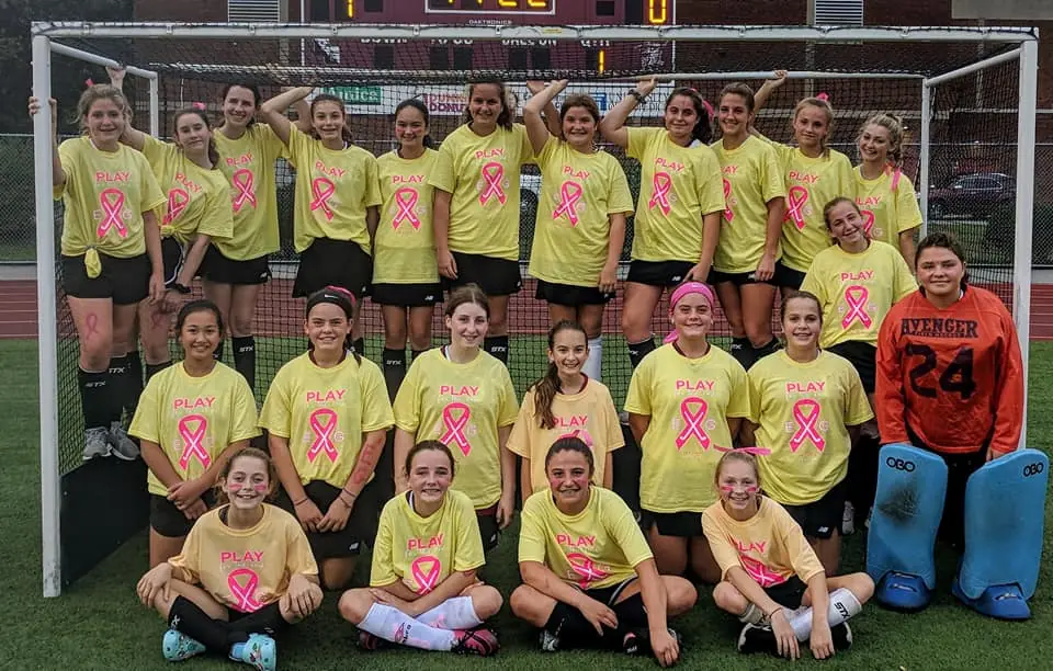 East Greenwich High School Field Hockey after their Play4TheCure game East Greenwich High School Field Hockey together wearing yellow shirts with pink ribbons